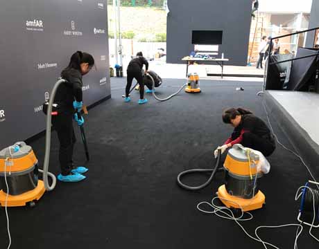 Cleaning crew using industrial wet-dry vacuums to clean a large event venue floor before or after a corporate event in Phoenix, AZ